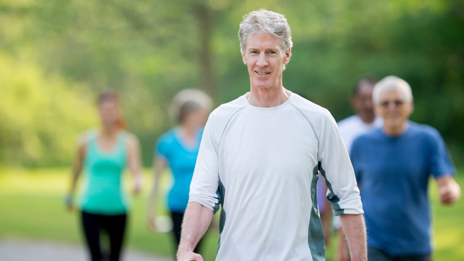 Man in fitness fitness attire leading a walking group outdoors